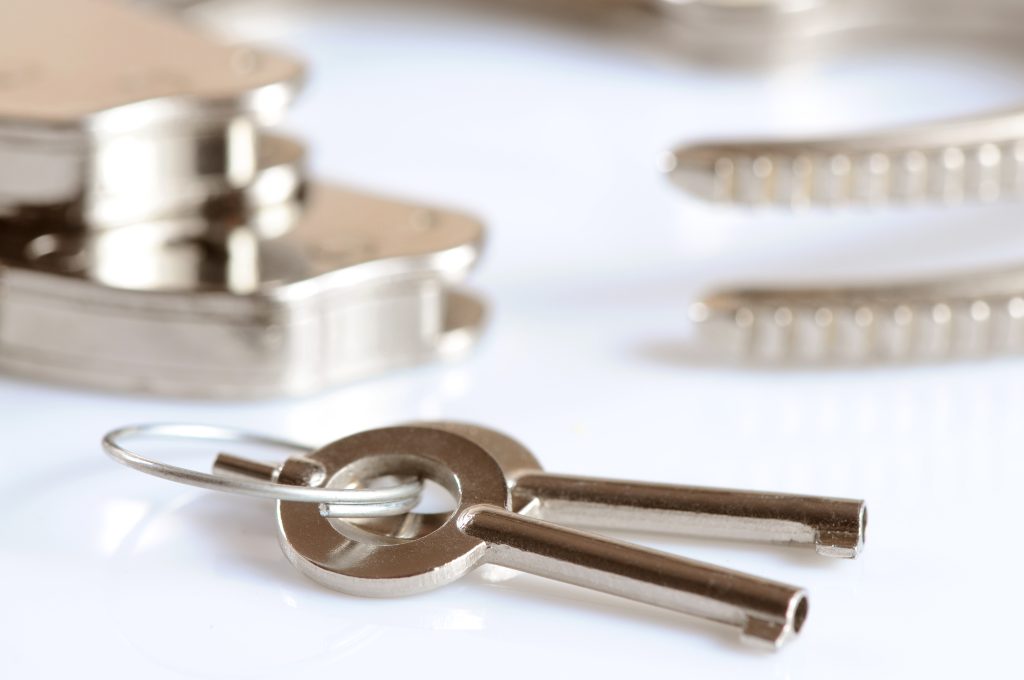 metal handcuffs and keys isolated over white background